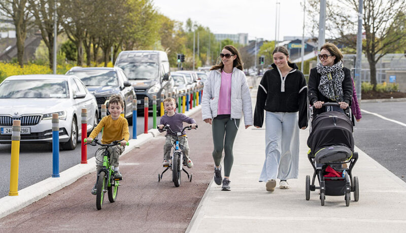 children in cyclelane - pencil posts- 3 women walking one with baby buggy