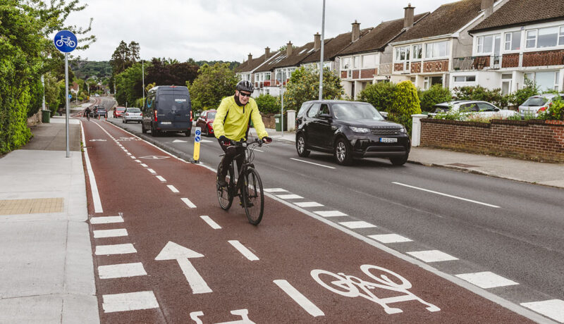 cyclist on a 2-way cycle lane - with passing car traffic - Walking and Cycling Index