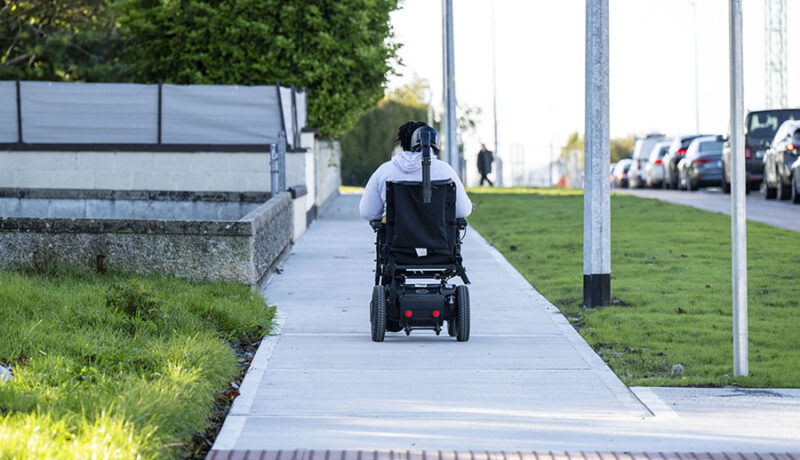 electric wheelchair user on footpath