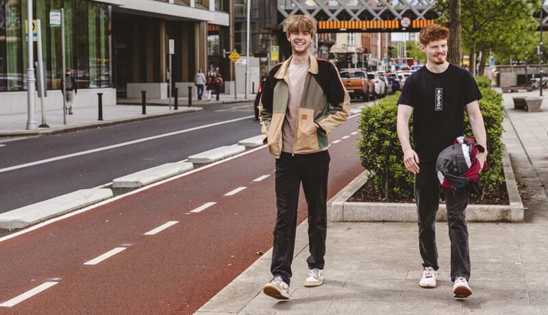 two men walking near cycle lane in Dublin street