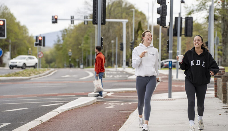 two walkers chatting smiling with coffee in Limerick