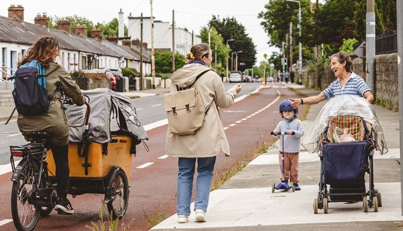 walker on foopath cyclist with carriage on cyclelane and woman with bbuggy and child on scooter 900x600